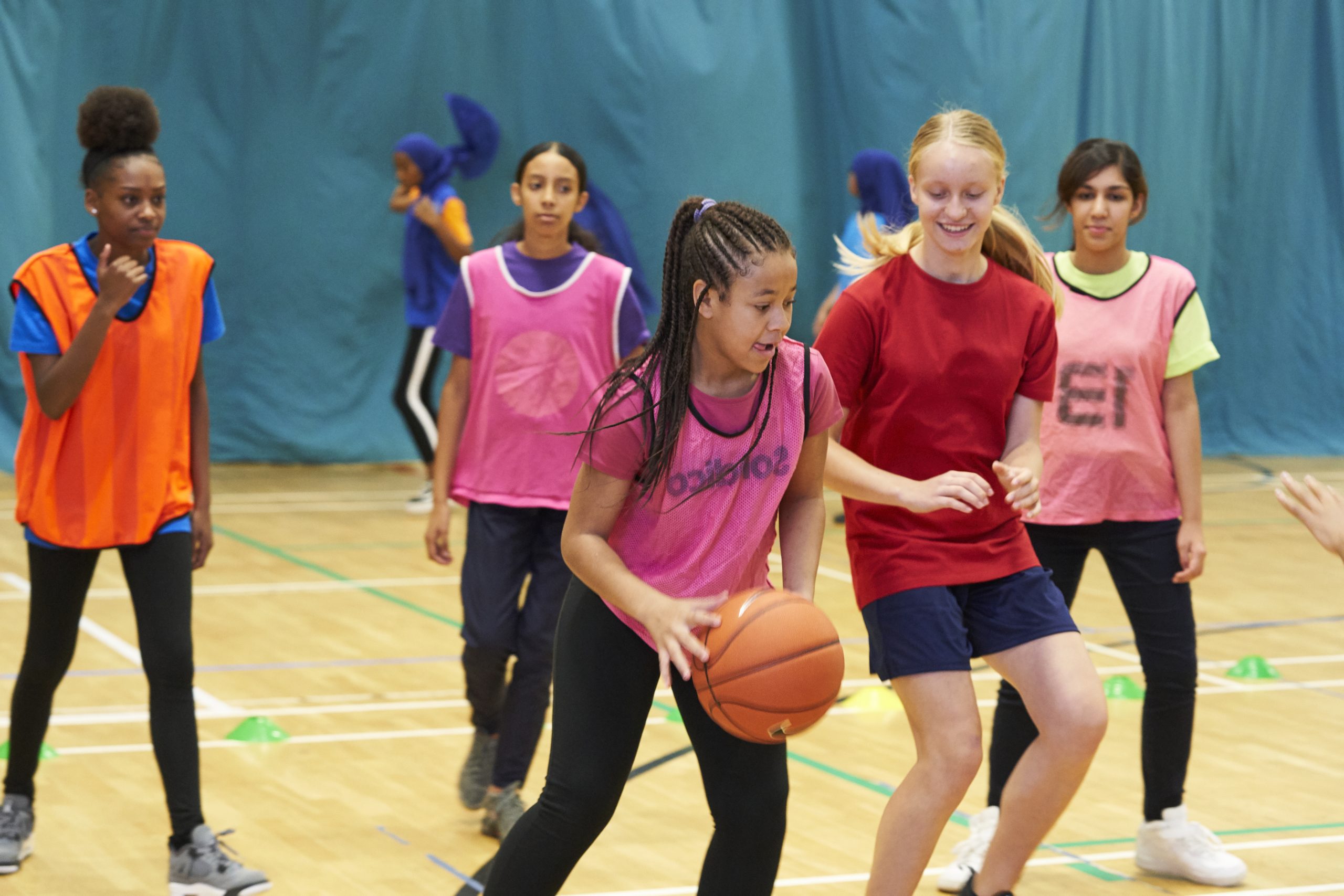 A group of young high school girls playing basketball
