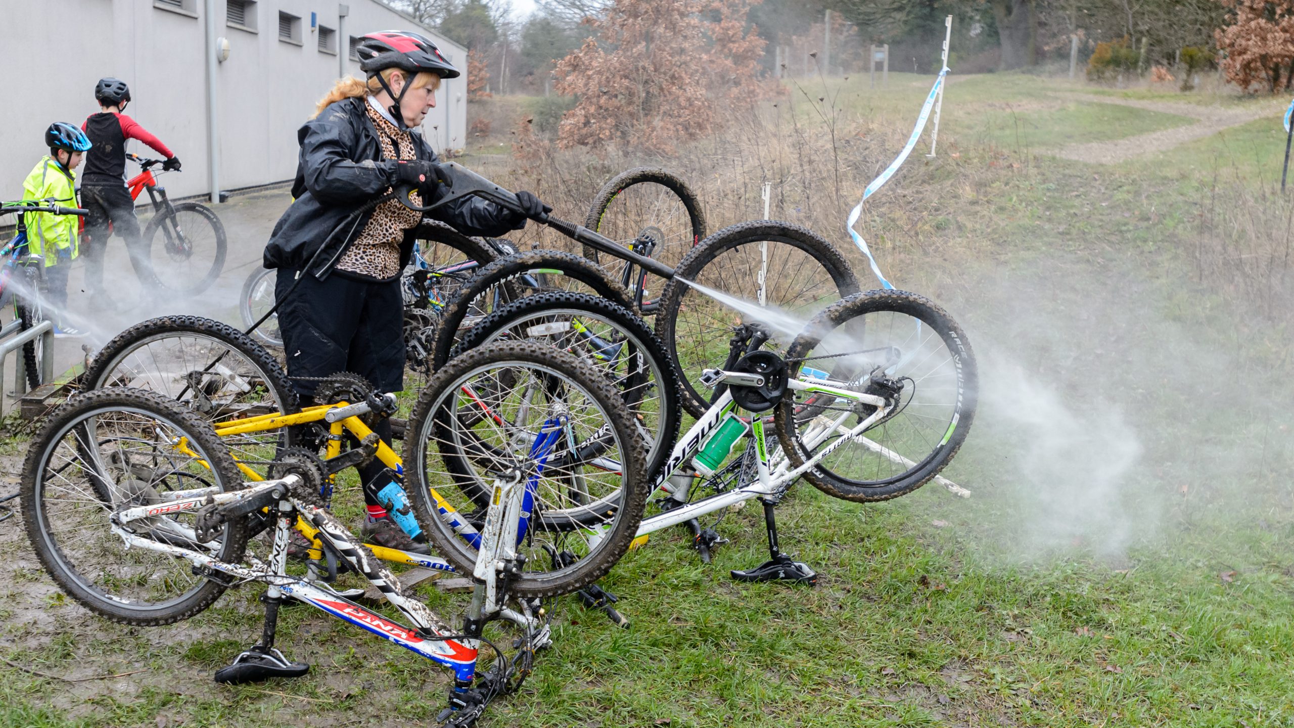 Woman hosing down mountain bikes to clean them
