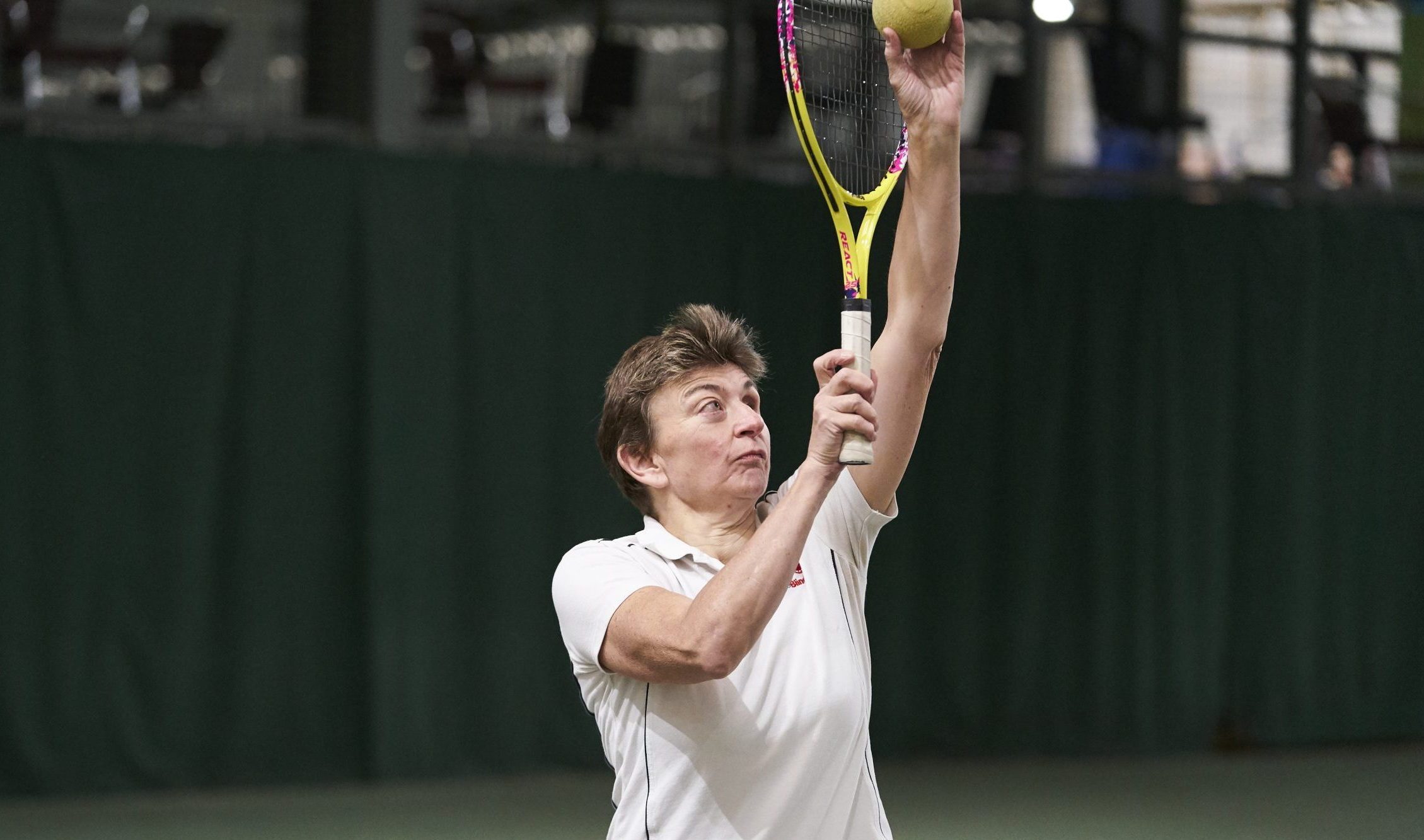 White woman with visual impairment playing tennis