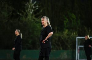 White woman aged 50-60 smiling while playing football