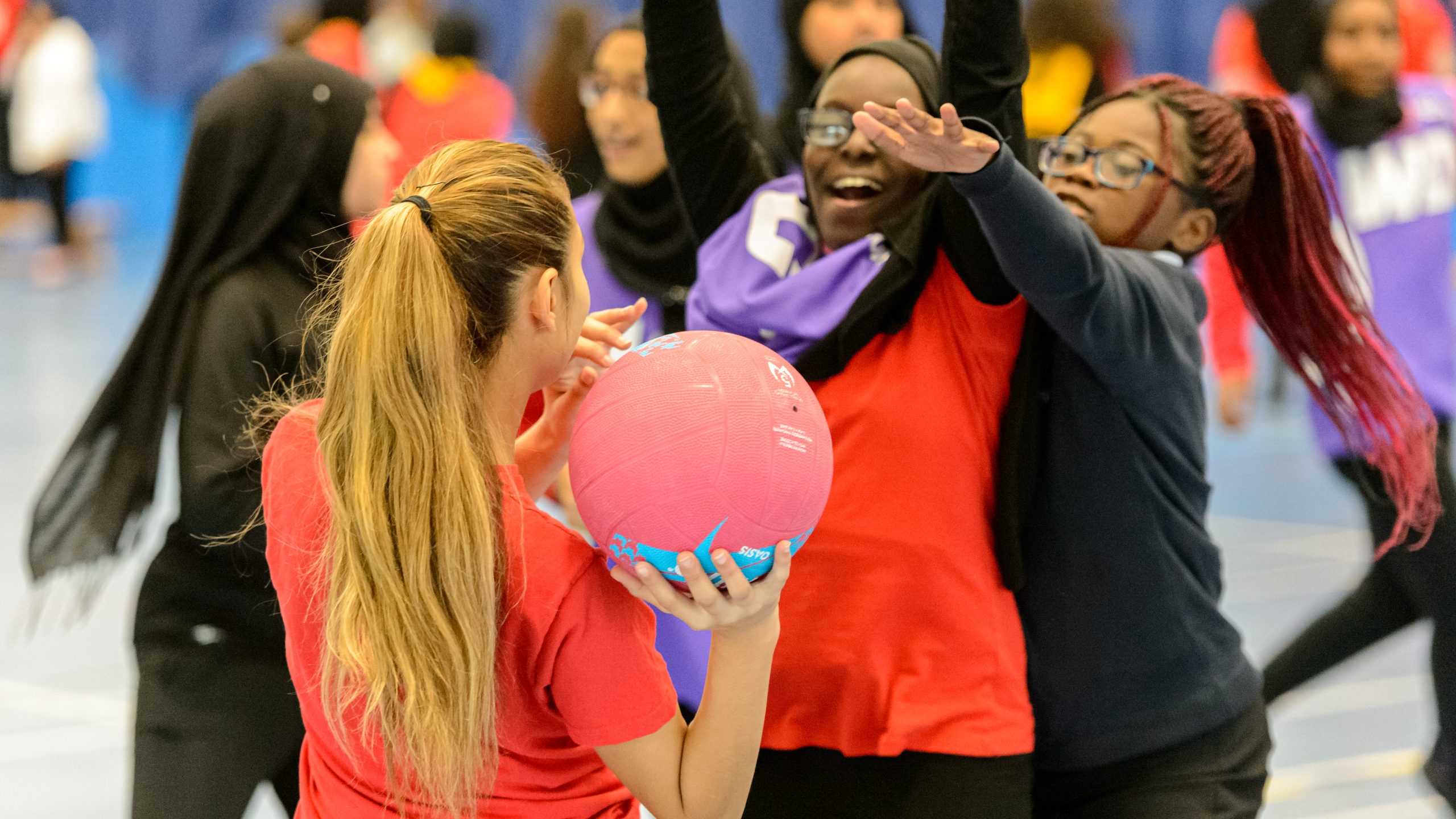 A group of teenagers from different backgrounds playing school netball