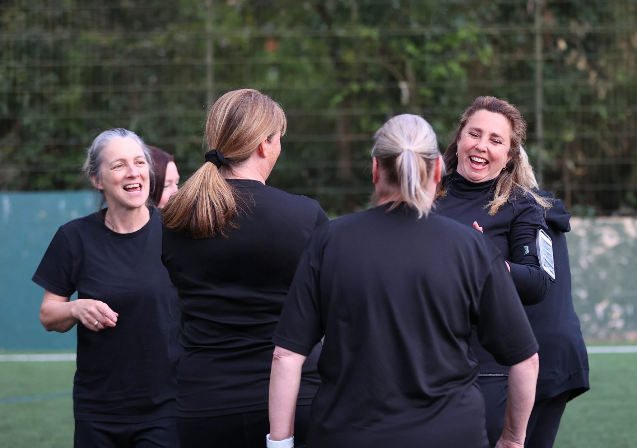 A group of white women aged 40-60 chatting during their football session