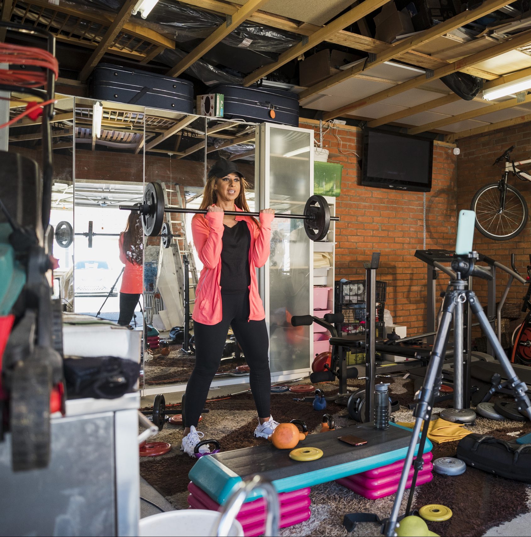 South Asian woman aged 45-55 weightlifting in her garage