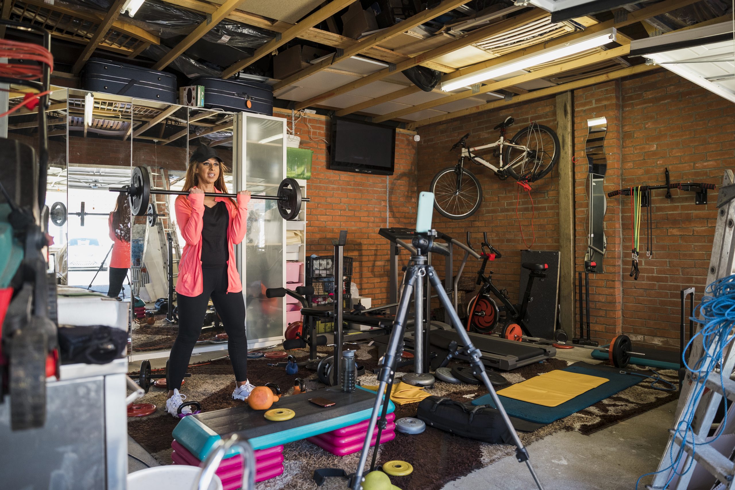 South Asian woman aged 45-55 weightlifting in her garage