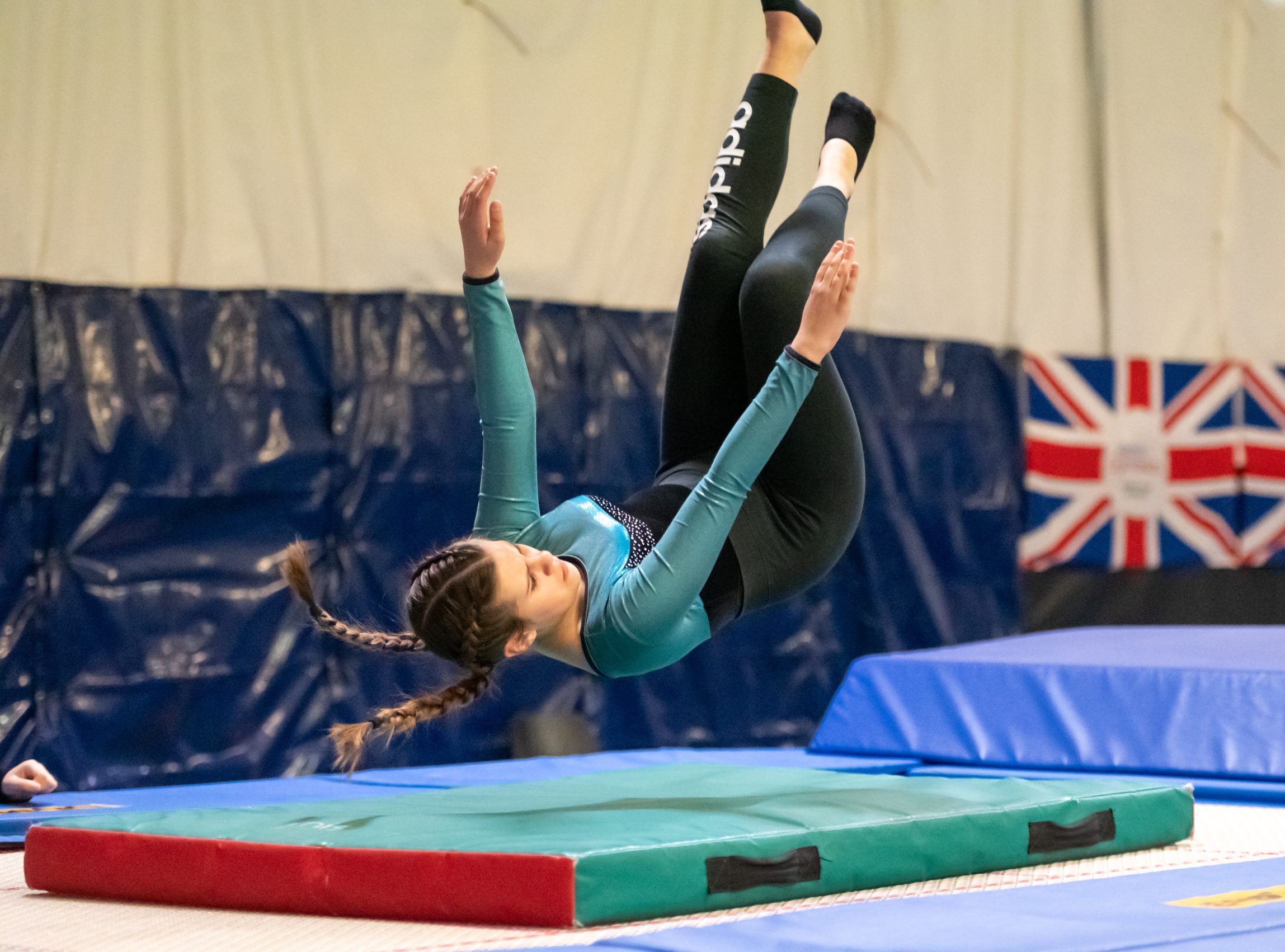 White teenage girl performing a gymnastics tumble