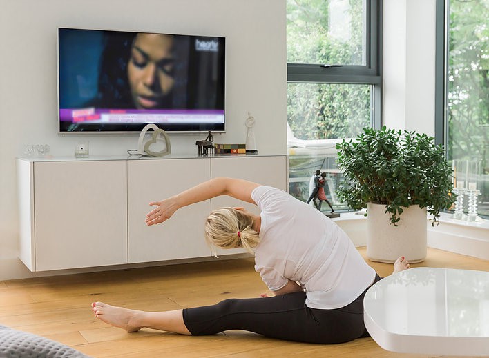Woman stretching in front of television