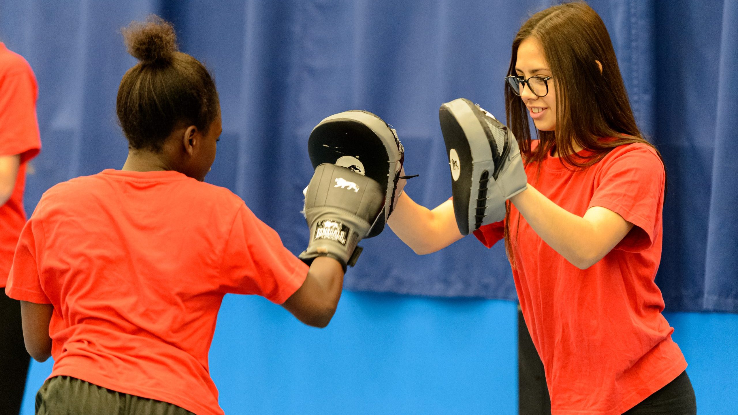 Two high school girls practicing boxing