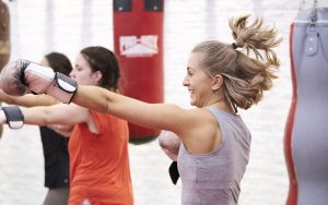 Blonde woman age 30-35 boxing with a smile on her face