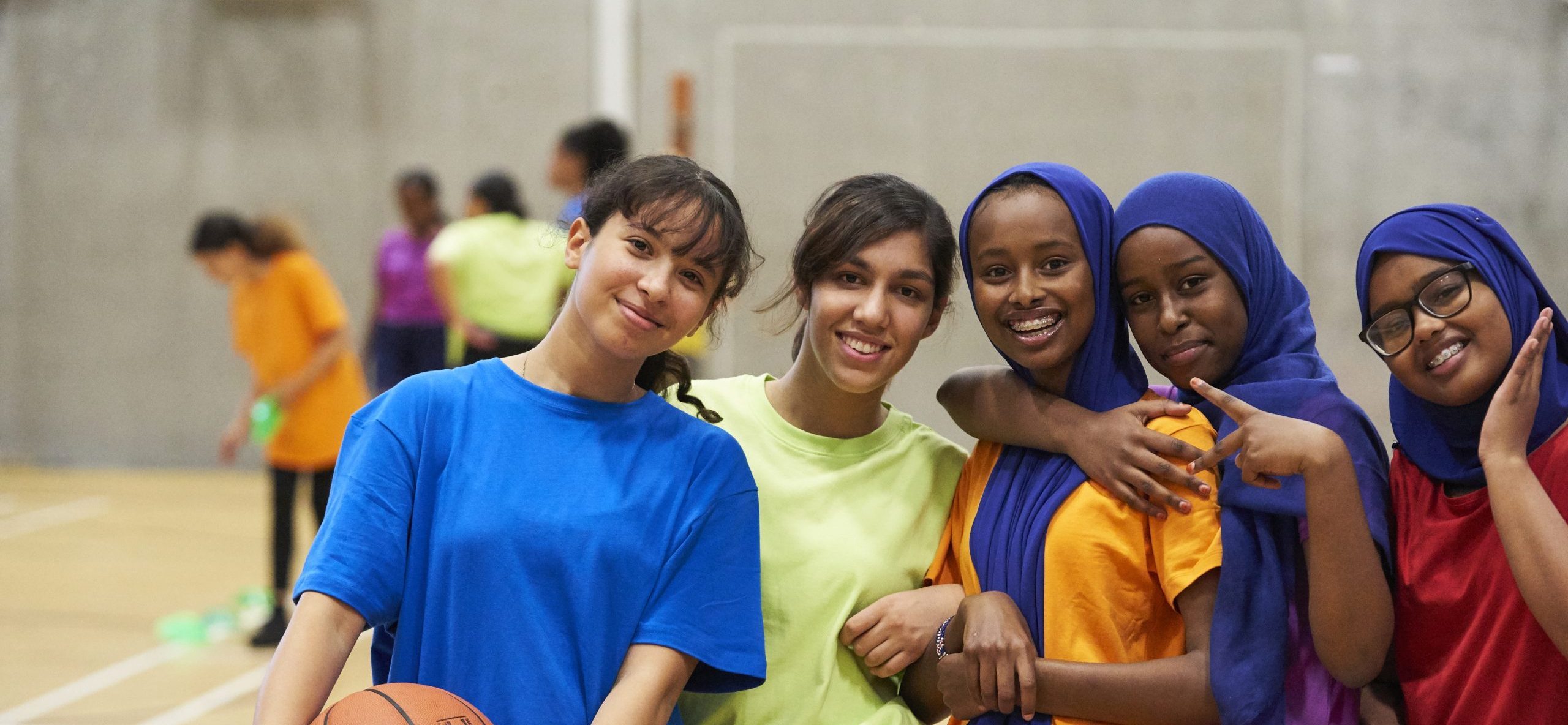 A group of teenage girls playing basketball at school