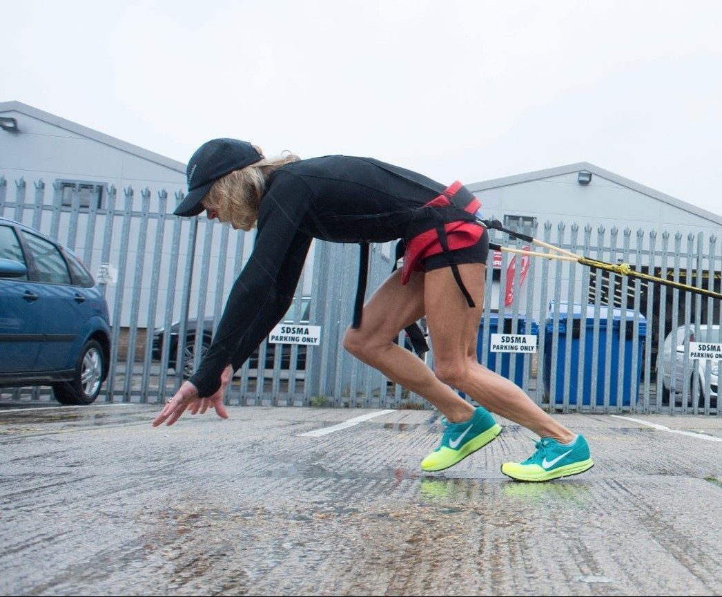 Rosie training by pulling a car via a cable wrapped round her waist