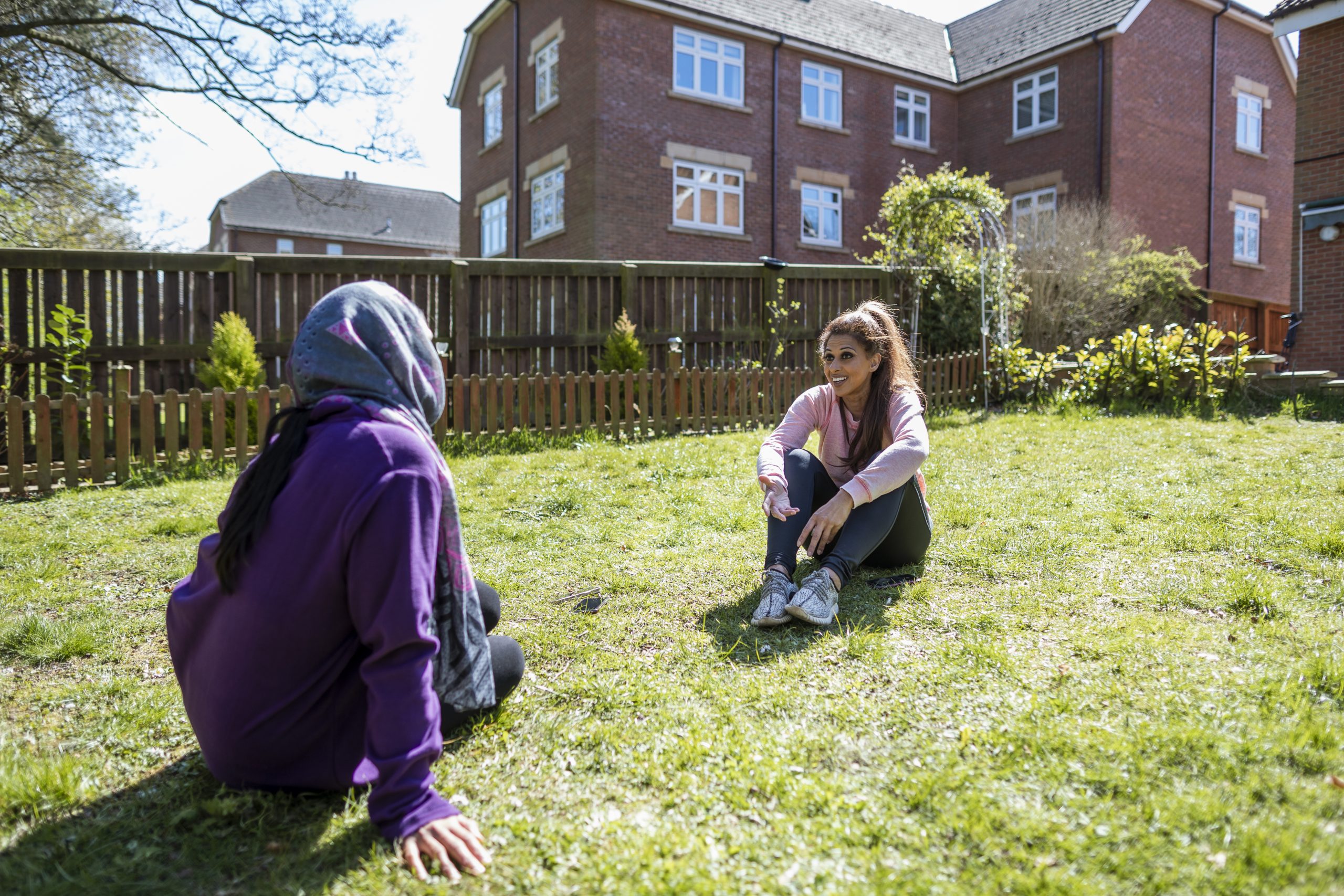 Shazia, a 45-55 year old south asian woman sitting in her garden