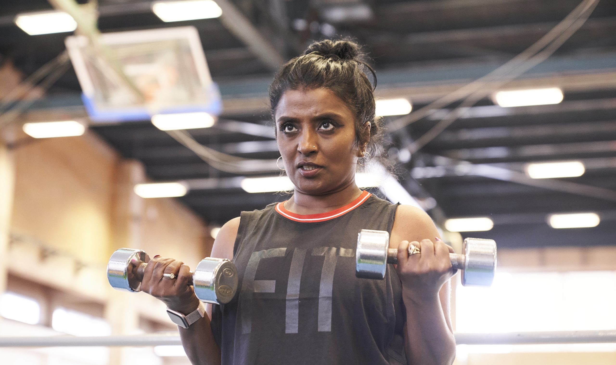 South Asian Woman weightlifting small weights