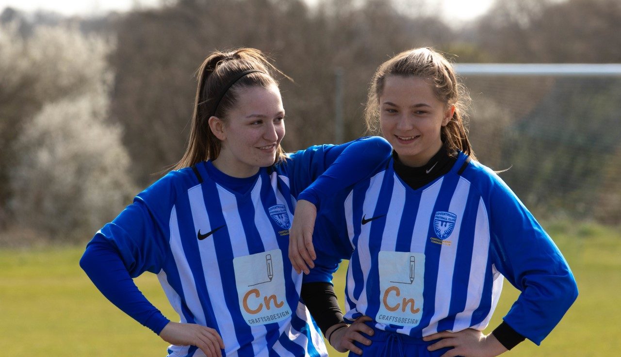 Two teenage girls playing football