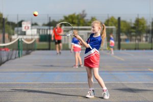 Young girl hitting a ball with a tennis racket