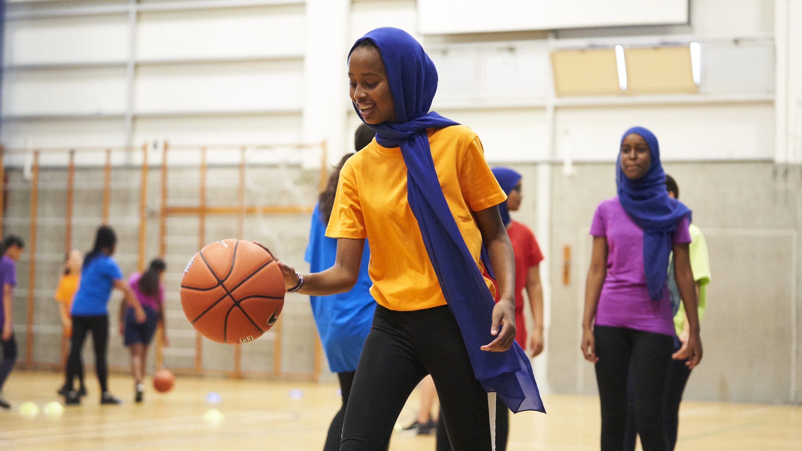 Muslim girl playing basketball at school