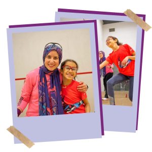 A mum and daughter playing squash together. the mum is wearing a headscarf