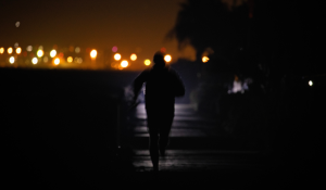 A woman running on a dark path at night