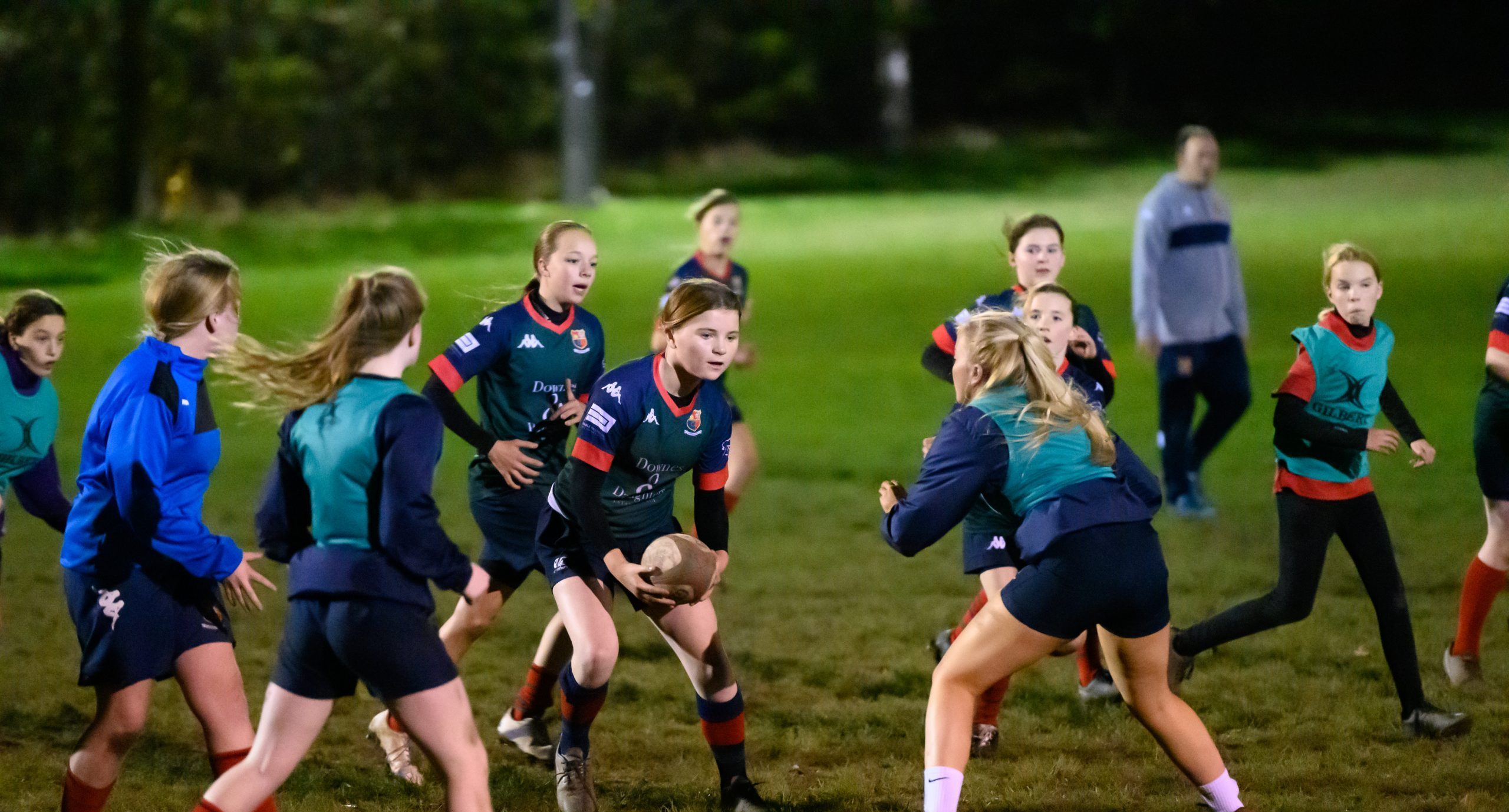 Teenage girls playing rugby
