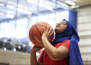 Young muslim girl preparing to throw a basketball