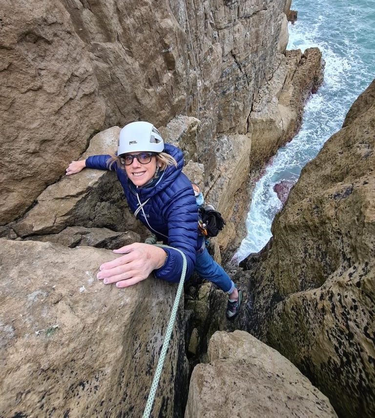Polly Neate CBE, CEO of Shelter, climbing on a sea cliff in Dorset