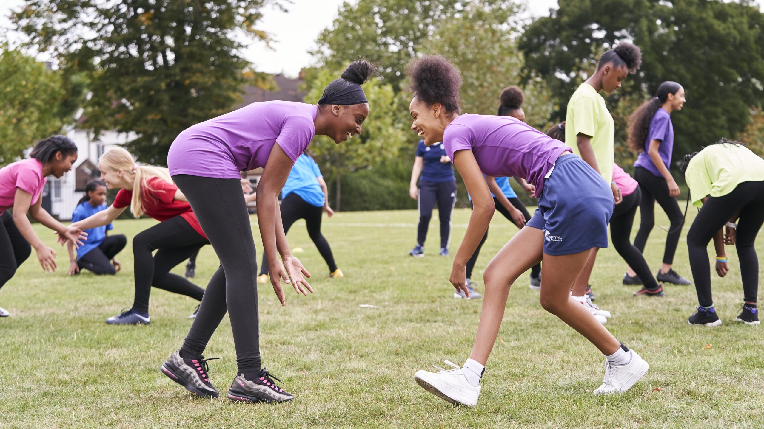 Two black teenage girls playing rugby at school