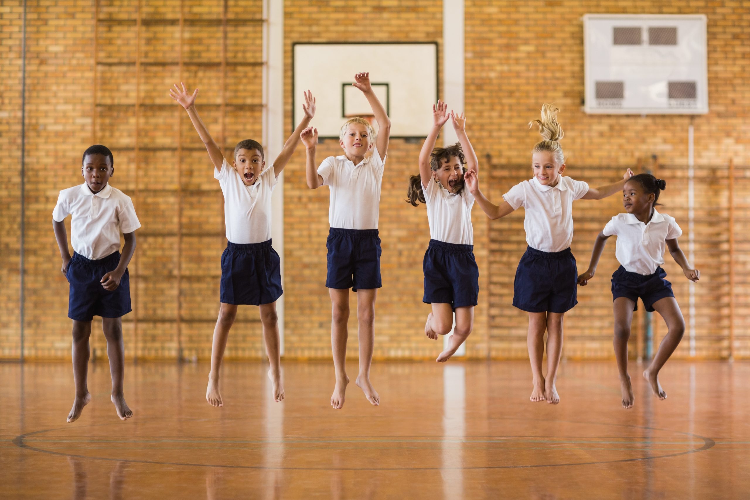 Group of students jumping in the school gym
