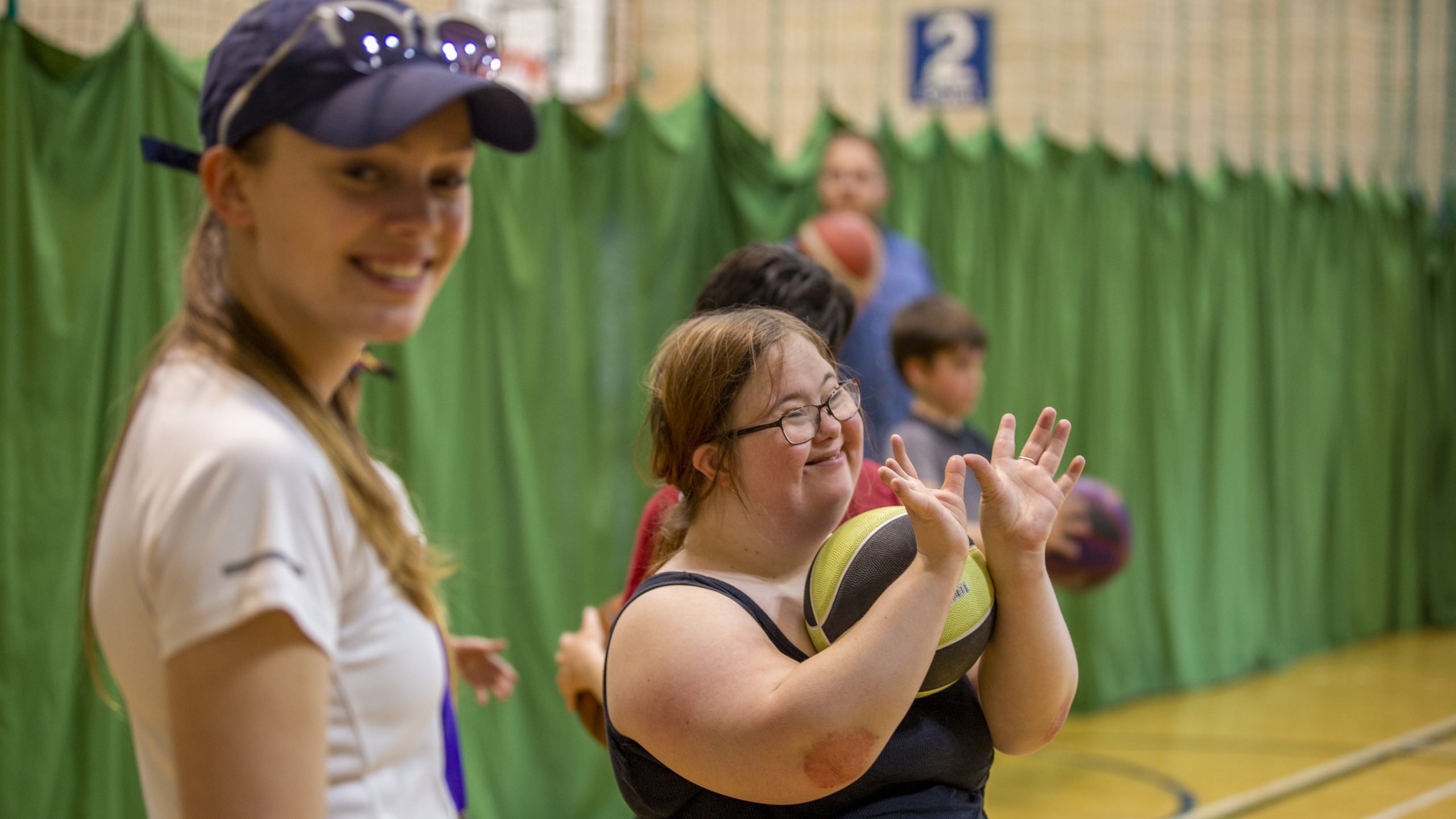 A girl with down syndrome and a volunteer taking part in a sport class