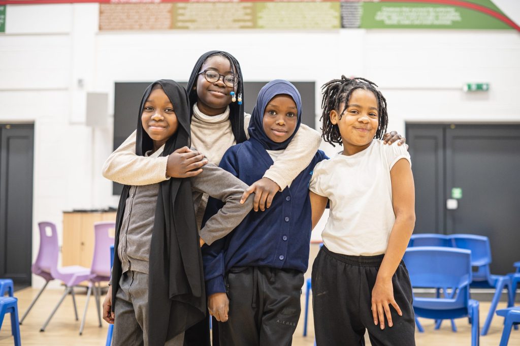 four school girls standing arm in arm