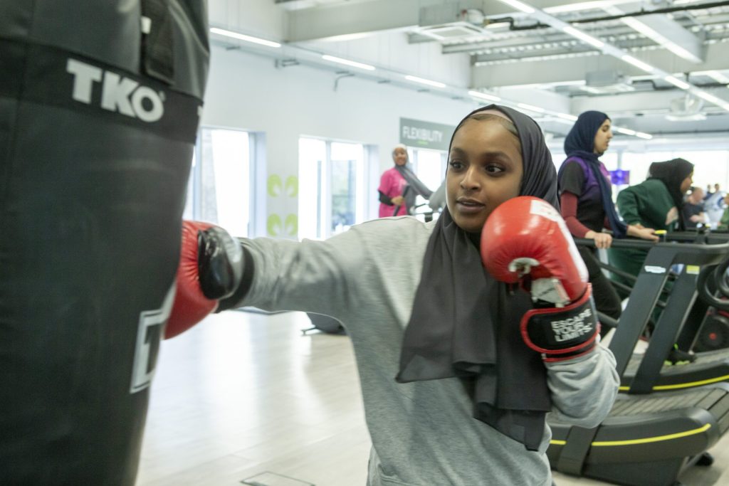 A muslim teenage girl boxing