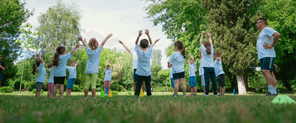 Young boys and girls doing a PE lesson in their school field