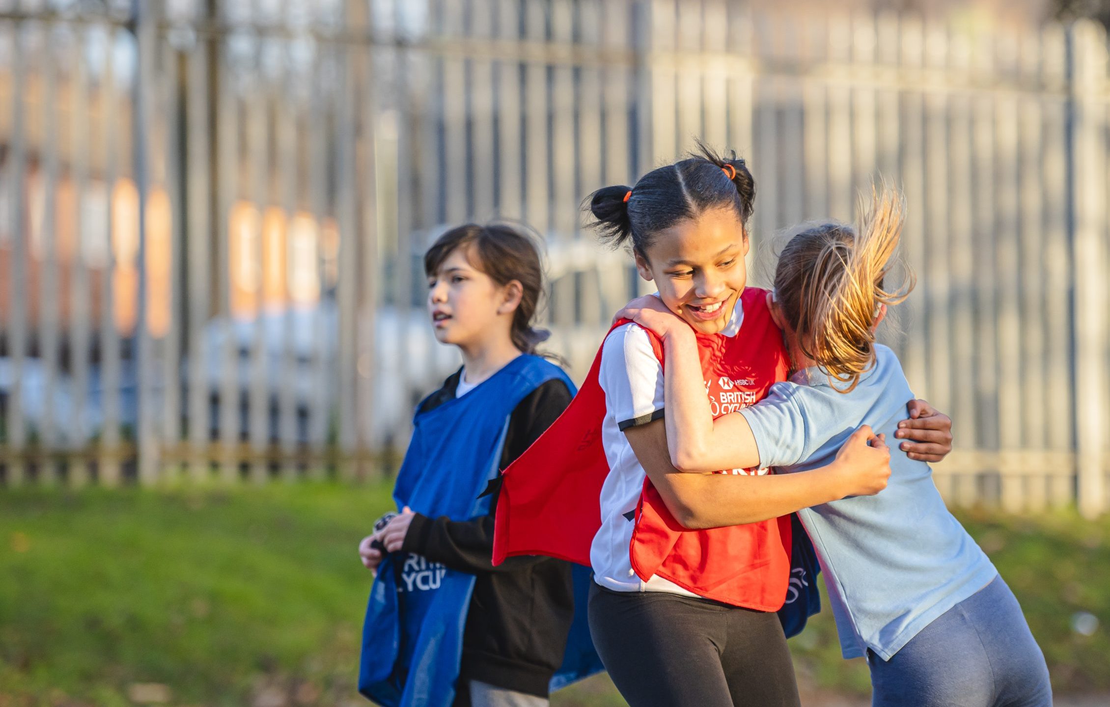 Two primary school girls playing football, celebrating