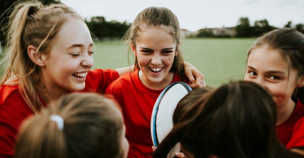 A group of teenage girls playing rugby at school