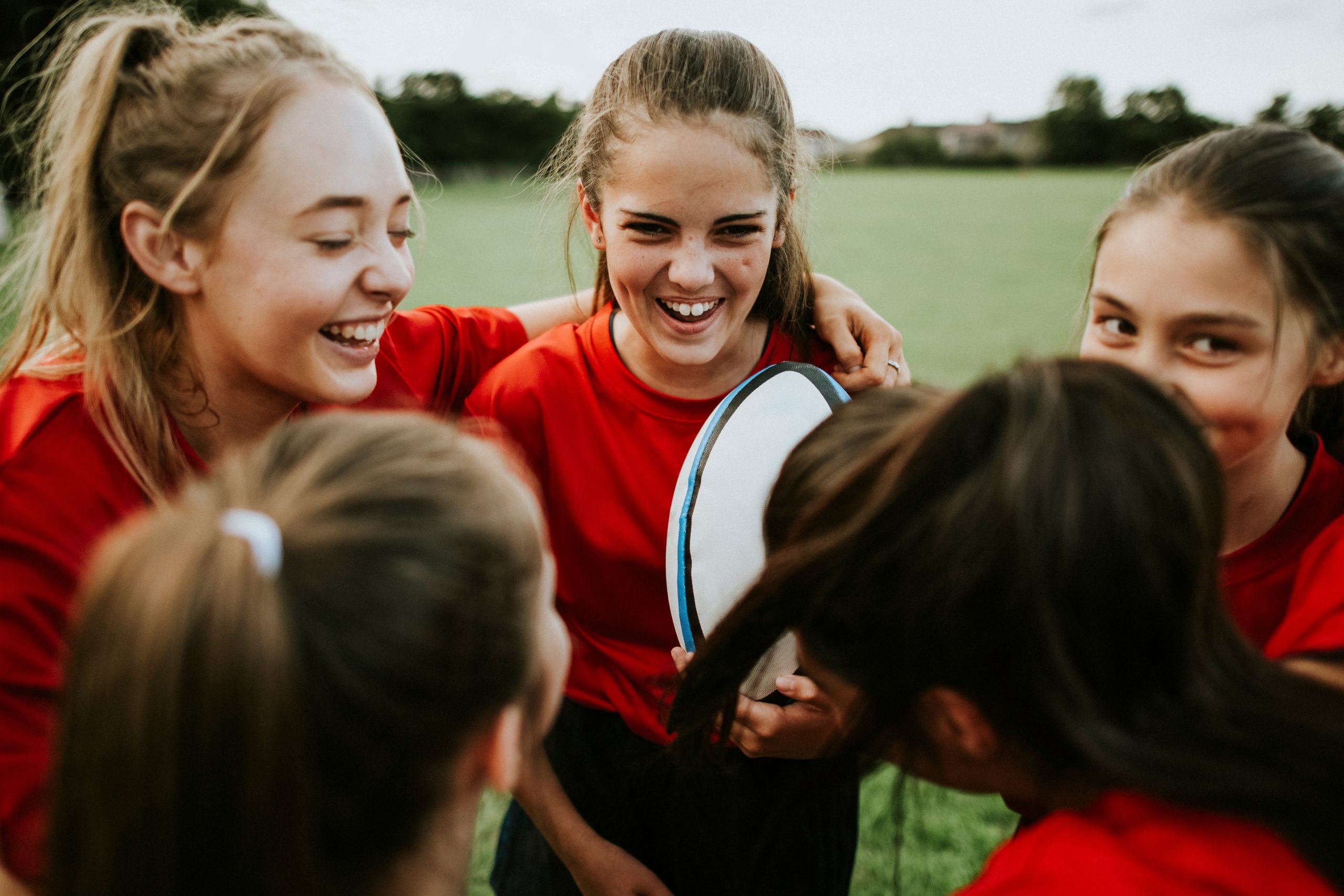 A group of teenage girls playing rugby at school
